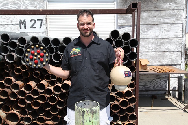 Paul Souza, son of Jim Souza, shows the aerial firework shell and how it goes in the mortar and a half-cut of model (pictured here) showing the red and blue composition. Aerial photo of red/blue explosion. Photo courtesy James R. Souza for Pyro Spectaculars by Souza, http://pyrospec.com (Rick Sforza)