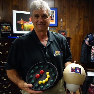 Jim Souza, president of Pyro Spectaculars, poses with samples of some of the fireworks he’s planning for this year’s Macy’s show. (James Delahoussaye/NPR)