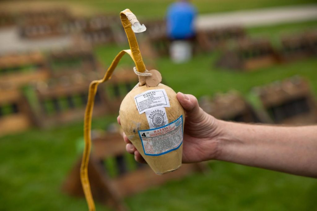 Larry Sunderland carefully holds up a four-inch firework shell, labeled "Dahlia Green," which will detonate at Wednesday’s Fourth of July firework show in Riverfront Park in Spokane. The four-inch shells are the largest at the Spokane show; they are launched 400 feet into the air. (Libby Kamrowski / The Spokesman-Review)