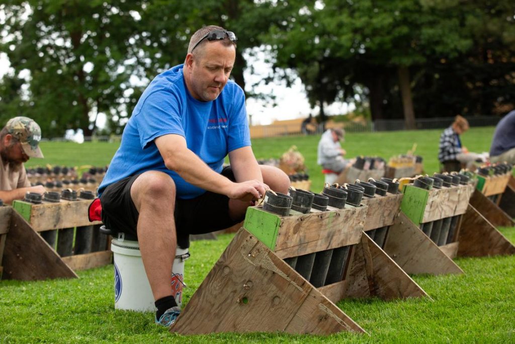 Brian Schmidt, a second-year volunteer with Pyro Spectaculars, helps set up rows of shells in Riverfront Park on Tuesday, July 3, 2018, for the Fourth of July fireworks show. (Libby Kamrowski / The Spokesman-Review)