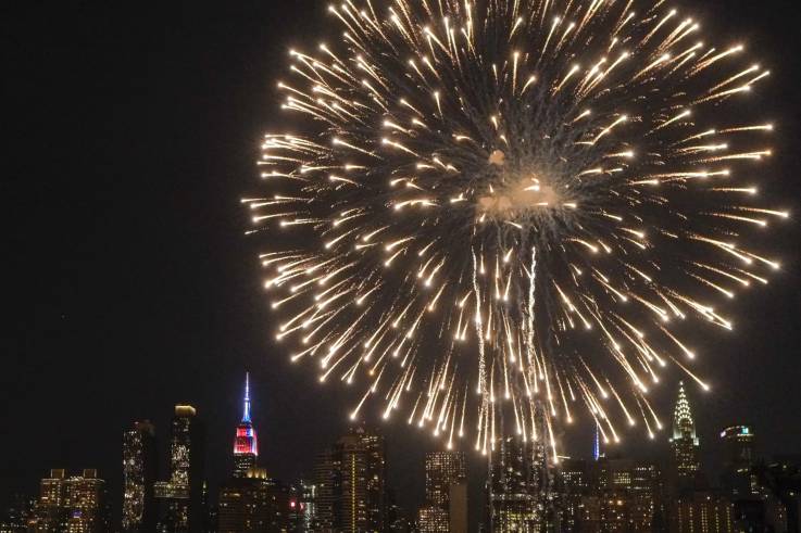 The Empire State Building is lit in blue, white and red as people watch the Macy's Fourth of July Fireworks from Hunter Point Park on July 4, 2018 in New York City. EDUARDO MUNOZ ALVAREZ/GETTY