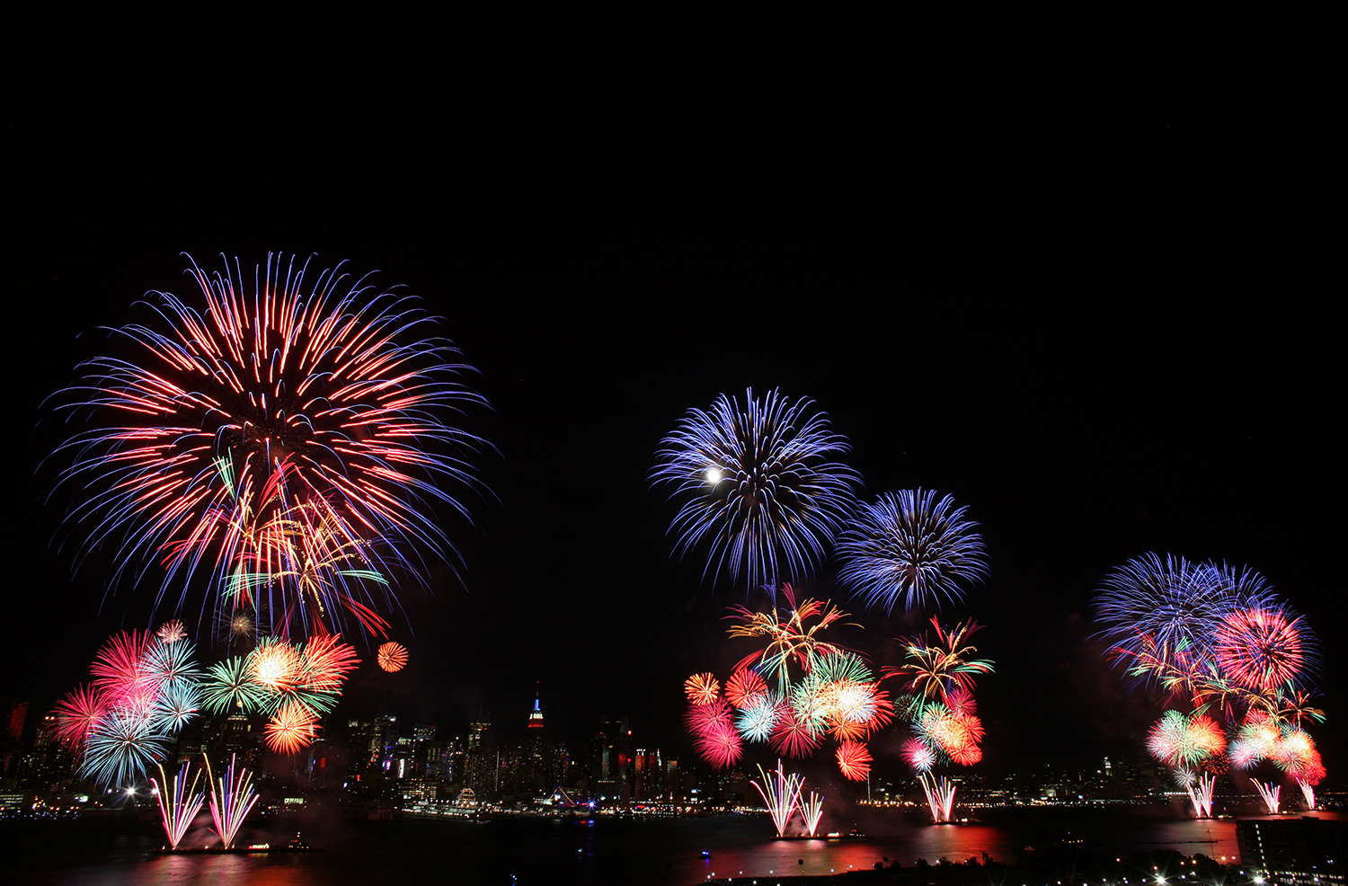 WEEHAWKEN, NJ. - JULY 4: The New York City skyline is seen in the distance as fireworks explode over the Hudson River during the Macy's fireworks display July 4, 2009 in Weehawken, New Jersey. It was the first time since 2000 that the Macy's display took place over the Hudson River and not the East River. (Photo by Yana Paskova/Getty Images)